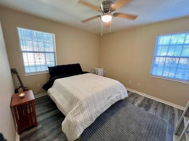 bedroom with dark hardwood / wood-style flooring and ceiling fan