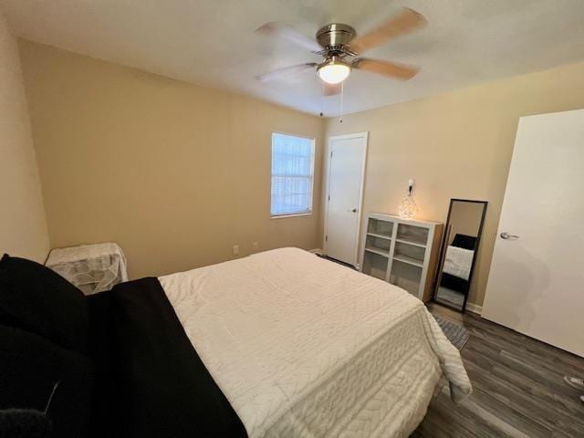 bedroom with dark hardwood / wood-style flooring and ceiling fan