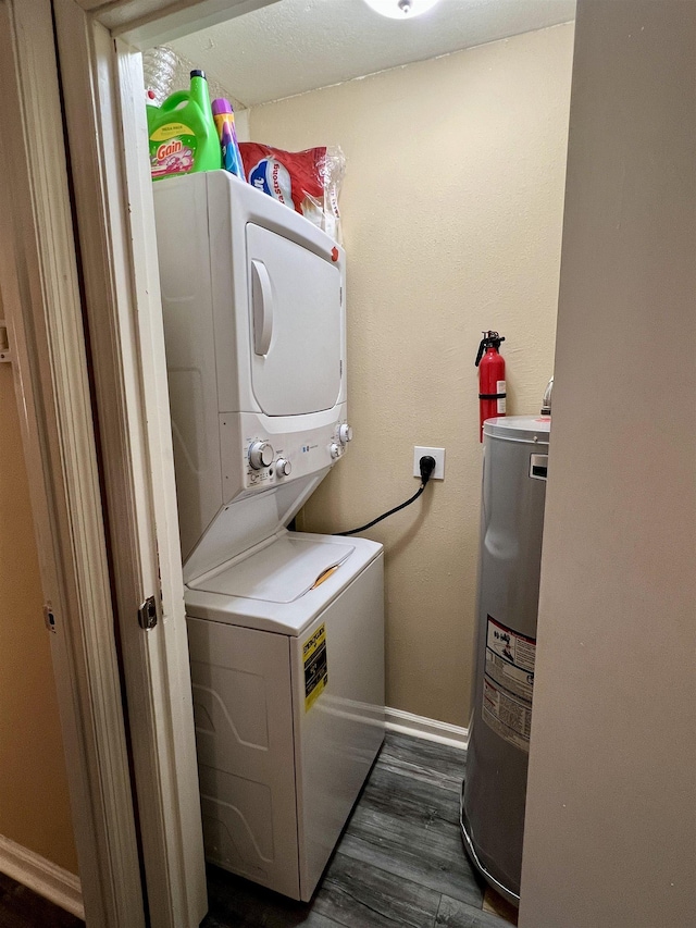 laundry area with stacked washing maching and dryer, electric water heater, and dark hardwood / wood-style flooring