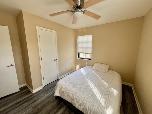 bedroom with ceiling fan and dark wood-type flooring