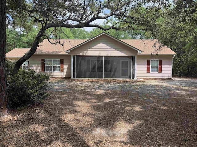 rear view of property featuring a sunroom