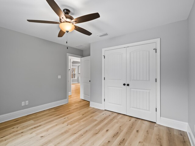 unfurnished bedroom featuring ceiling fan, a closet, and light hardwood / wood-style floors