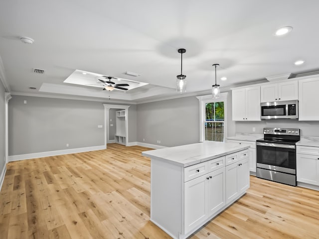 kitchen featuring light wood-type flooring, white cabinetry, stainless steel appliances, and ornamental molding