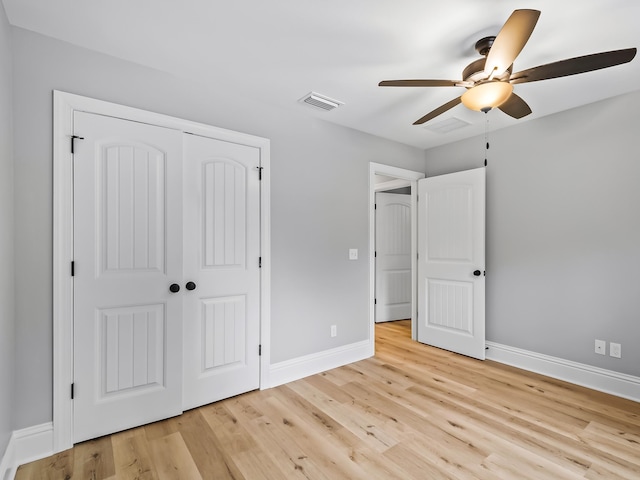 unfurnished bedroom featuring a closet, light hardwood / wood-style floors, and ceiling fan