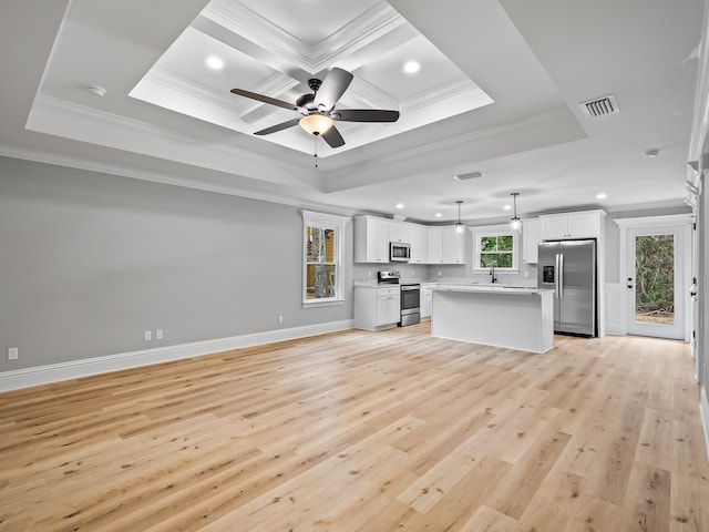 unfurnished living room with light hardwood / wood-style floors, sink, crown molding, and a tray ceiling