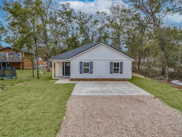 view of front of property featuring a patio area, a trampoline, and a front lawn