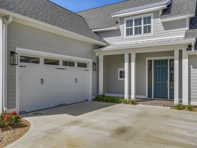 view of exterior entry featuring a porch and a garage