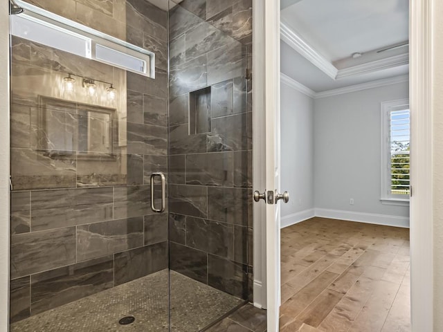 bathroom with hardwood / wood-style flooring, walk in shower, crown molding, and a tray ceiling