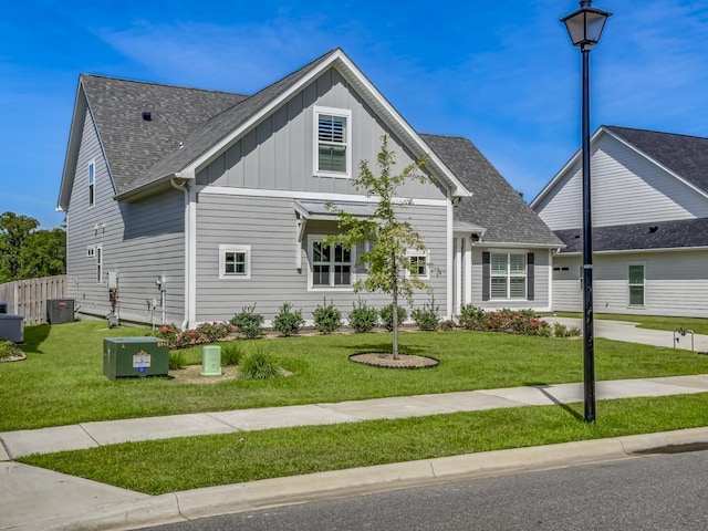 view of front facade featuring central AC unit and a front yard