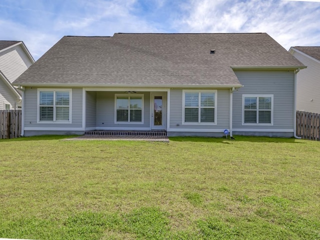 rear view of property with a yard