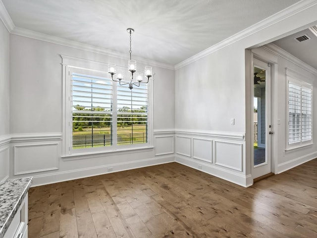 unfurnished dining area featuring ornamental molding, dark hardwood / wood-style flooring, and a notable chandelier