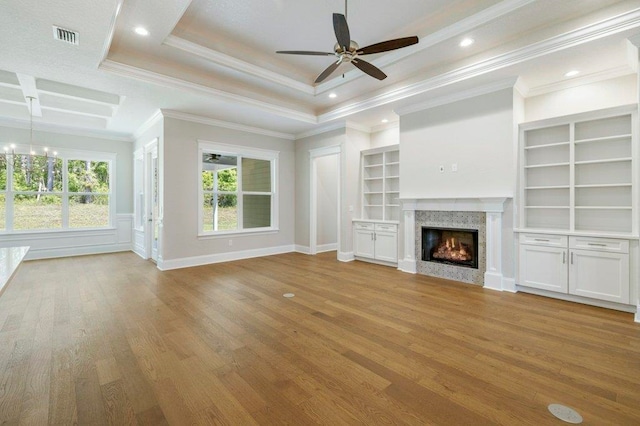 8451 Hickory Branch Trl, Tallahassee, FL 32312 - unfurnished living room featuring a ceiling fan, a warm lit fireplace, light wood-style floors, ornamental molding, and built in shelves