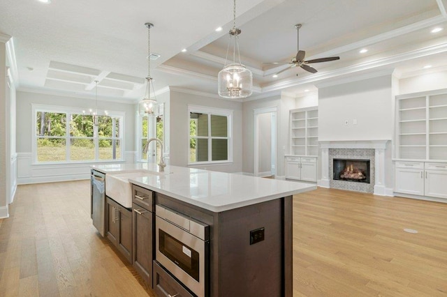 8451 Hickory Branch Trl, Tallahassee, FL 32312 - kitchen featuring appliances with stainless steel finishes, light wood finished floors, light countertops, a ceiling fan, and a center island with sink