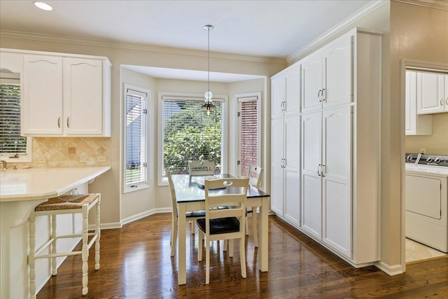 dining area featuring dark wood-style flooring, baseboards, and crown molding