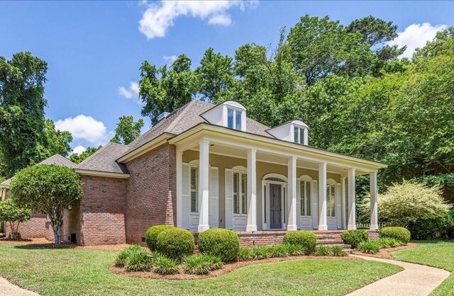 1370 Millstream Rd, Tallahassee, FL 32312 - greek revival house featuring brick siding, a front lawn, covered porch, and roof with shingles
