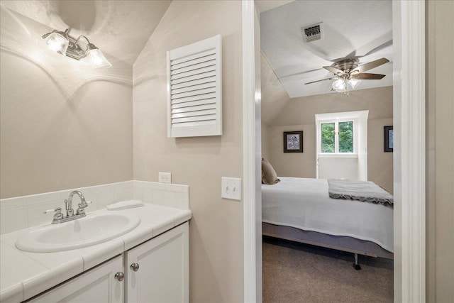 bathroom with vaulted ceiling, ceiling fan, connected bathroom, and vanity