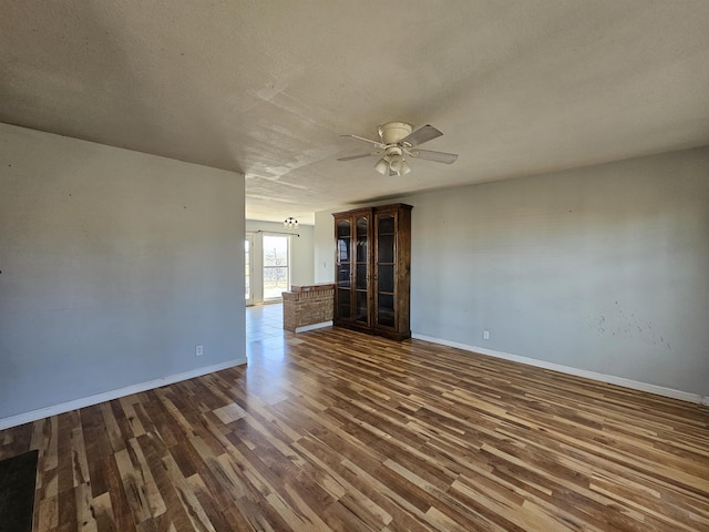 spare room with ceiling fan, a textured ceiling, and dark hardwood / wood-style flooring