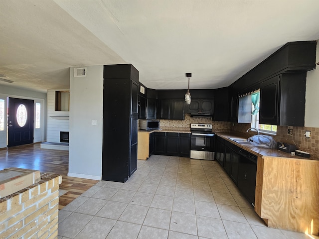 kitchen featuring appliances with stainless steel finishes, a healthy amount of sunlight, decorative light fixtures, and sink