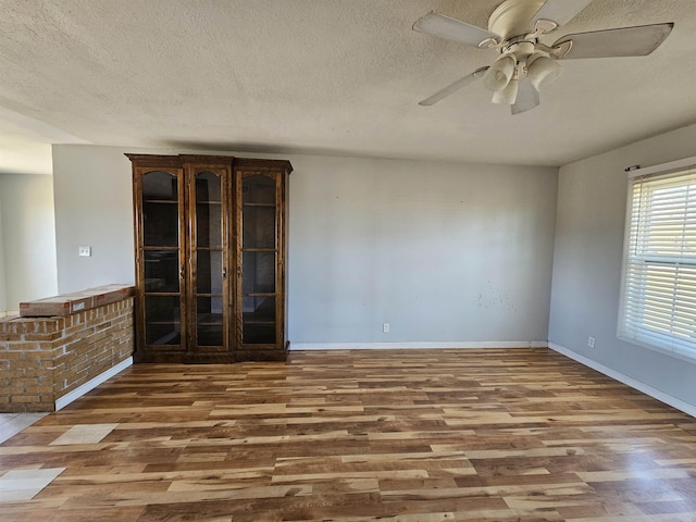 spare room with a textured ceiling, ceiling fan, and wood-type flooring