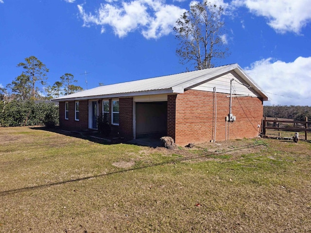 view of side of property featuring a garage and a yard