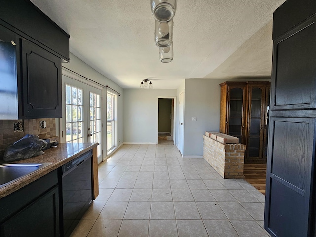 kitchen with light tile patterned floors, backsplash, dishwasher, and french doors