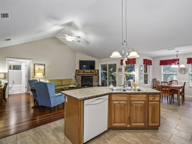 kitchen with ceiling fan, dishwasher, sink, light hardwood / wood-style floors, and a kitchen island with sink