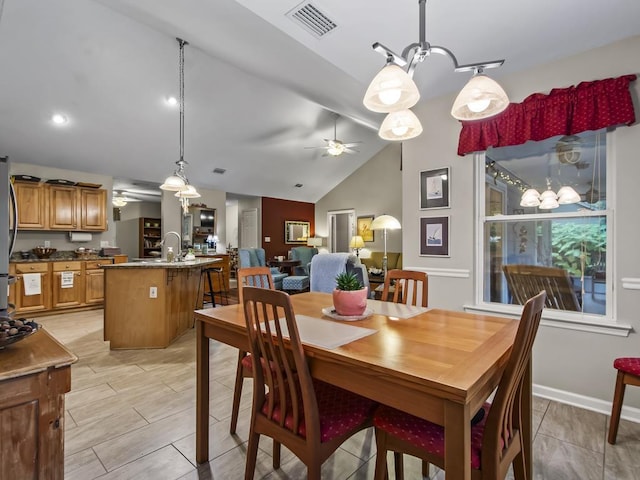 dining space with ceiling fan, lofted ceiling, and sink