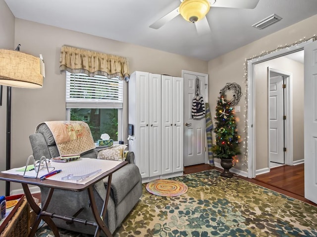 sitting room with dark hardwood / wood-style flooring and ceiling fan