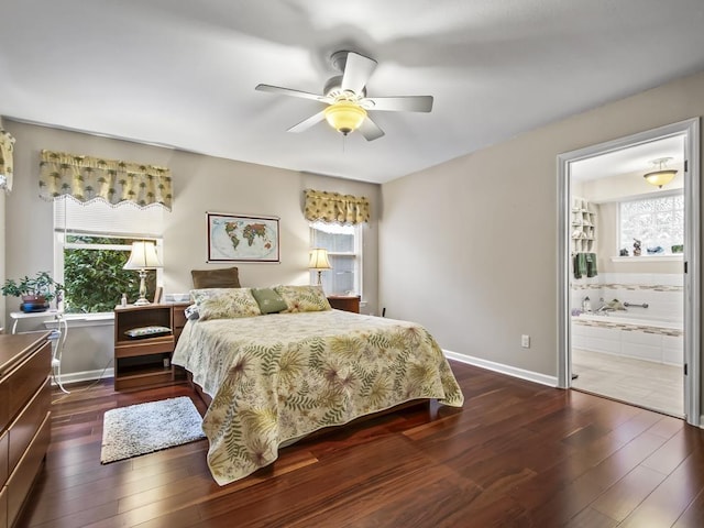 bedroom featuring dark hardwood / wood-style floors, ceiling fan, and ensuite bath