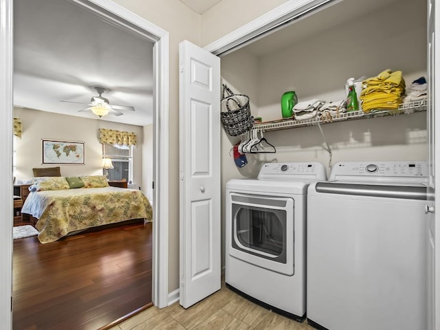 clothes washing area with washer and clothes dryer, ceiling fan, and light hardwood / wood-style flooring