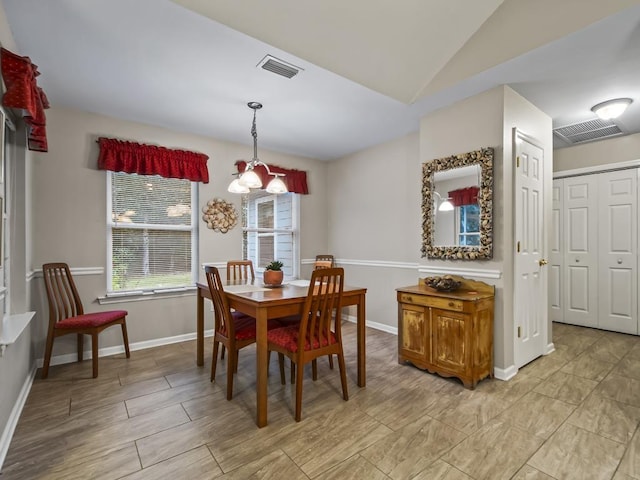 dining room featuring an inviting chandelier and vaulted ceiling