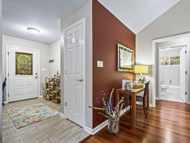 foyer entrance featuring hardwood / wood-style flooring and lofted ceiling