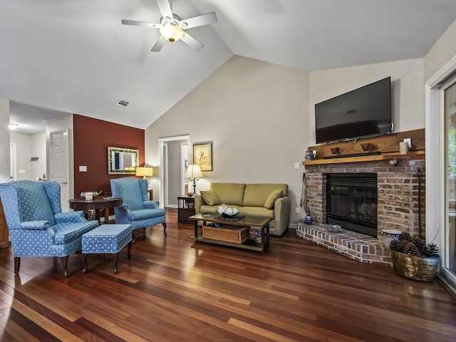 living room with hardwood / wood-style flooring, a brick fireplace, ceiling fan, and lofted ceiling