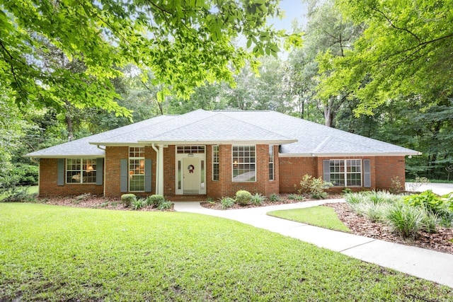 3540 Trillium Ct, Tallahassee, FL 32312 - single story home with a front lawn, brick siding, roof with shingles, and view of wooded area