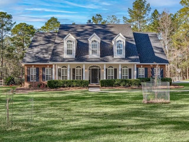 cape cod house with a front lawn