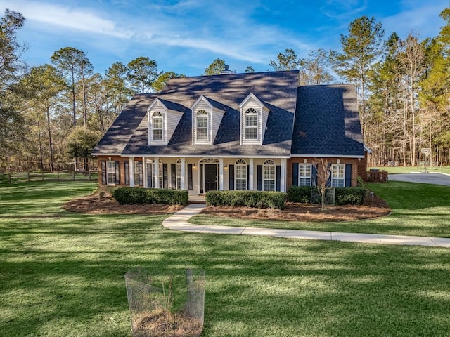 cape cod-style house featuring a front yard and covered porch