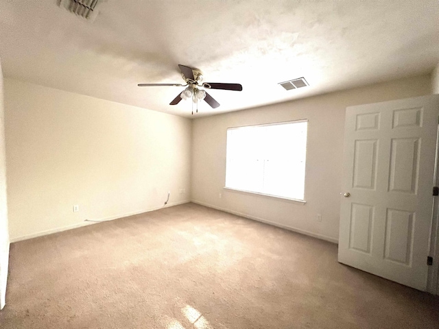 carpeted spare room with ceiling fan