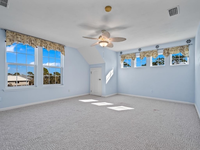 empty room featuring vaulted ceiling, ceiling fan, and carpet floors