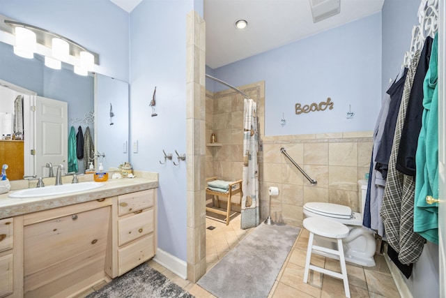 23380 Elmwood Ln, Live Oak, FL 32064 - bathroom with tile patterned flooring, vanity, tiled shower, tile walls, and a wainscoted wall