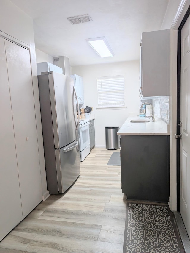 3137 Huttersfield Cir, Tallahassee, FL 32303 - kitchen with freestanding refrigerator, electric range, light countertops, and light wood-type flooring