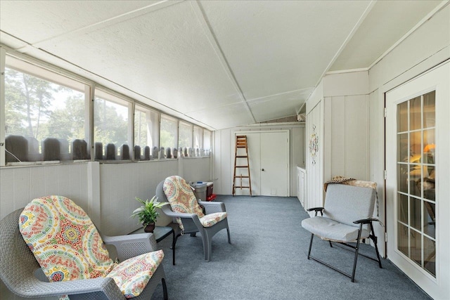 living area with carpet, wooden walls, and vaulted ceiling