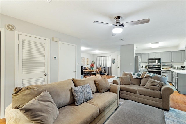 living room with light wood-type flooring and ceiling fan