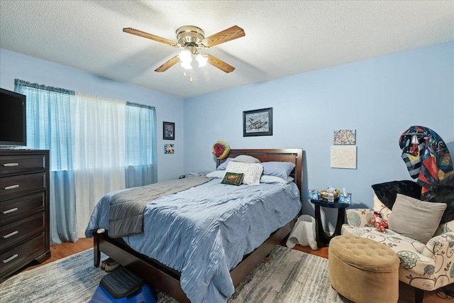 bedroom featuring hardwood / wood-style flooring, a textured ceiling, and ceiling fan