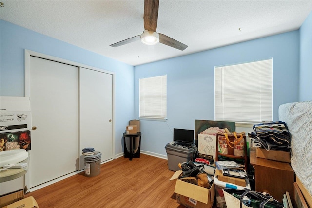 office area with a textured ceiling, ceiling fan, and light hardwood / wood-style flooring