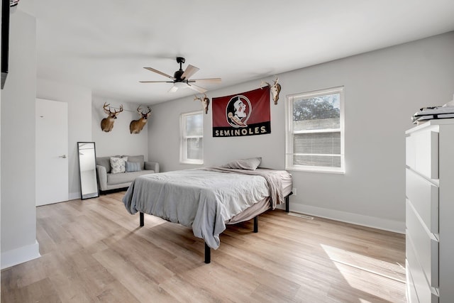 bedroom with light wood-style floors, baseboards, and a ceiling fan