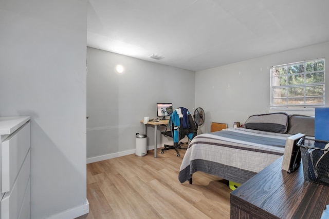 bedroom with light wood-type flooring, visible vents, and baseboards