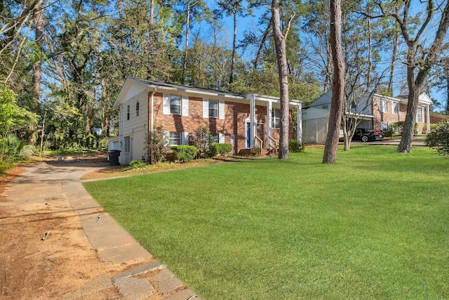 split foyer home featuring brick siding and a front lawn