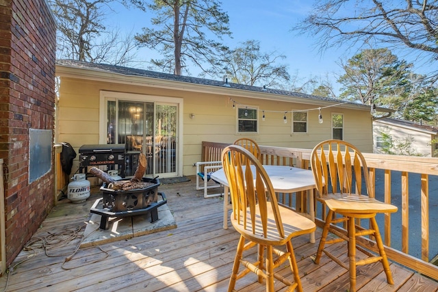 deck with outdoor dining area and a grill