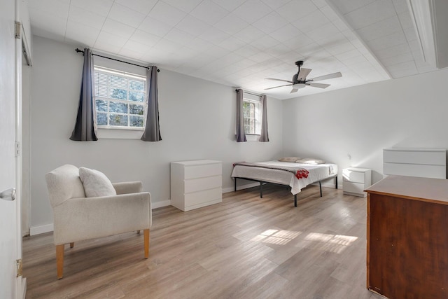 bedroom featuring light wood-style flooring, baseboards, and a ceiling fan