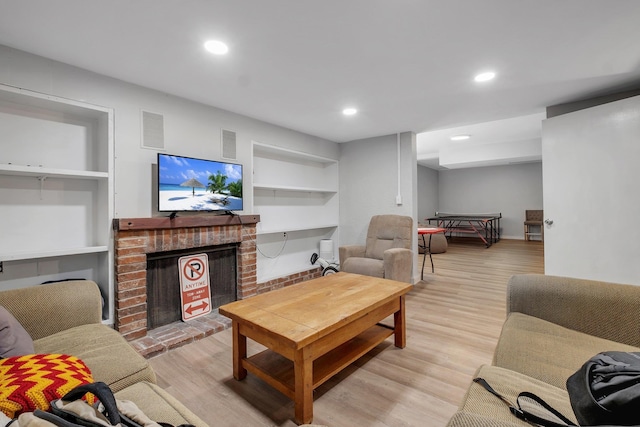 living room featuring recessed lighting, a brick fireplace, visible vents, and light wood-style floors